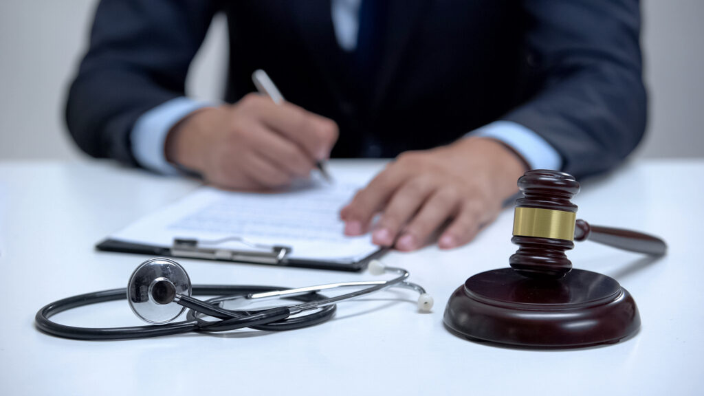 Judge signing arrest warrant for medical error, banging gavel near stethoscope