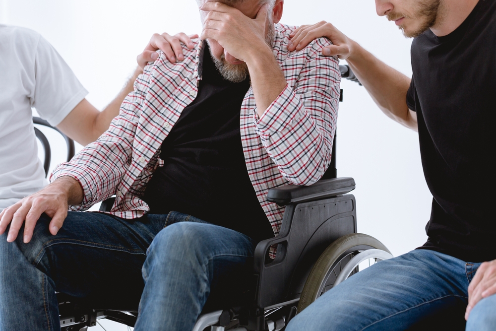 Friends,Supporting,Injured,Man,On,Wheelchair,During,Psychotherapy,For,People
