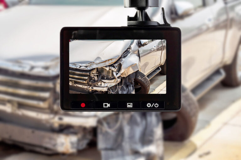 A dashcam is featured capturing a auto accident scene through a windshield.