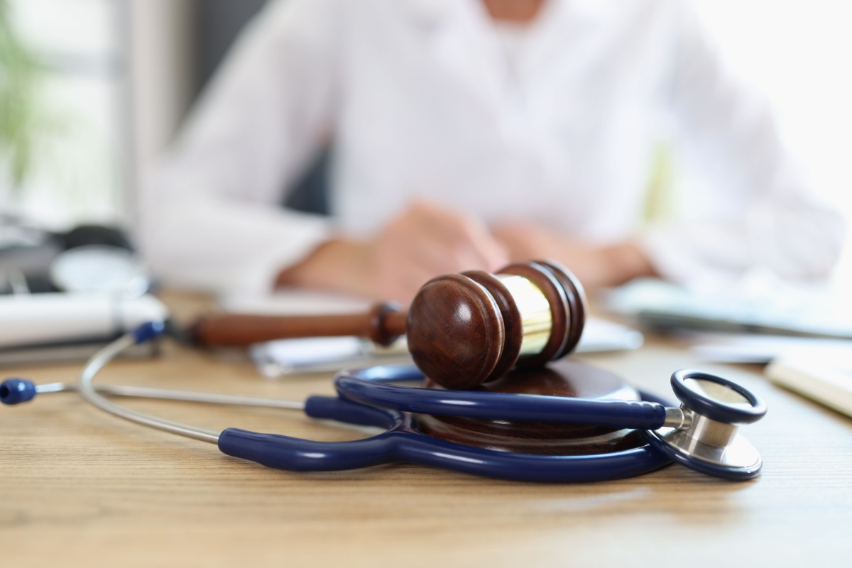 A medical doctor’s stethoscope alongside a gavel on a table, illustrating the connection between health and legal issues.
