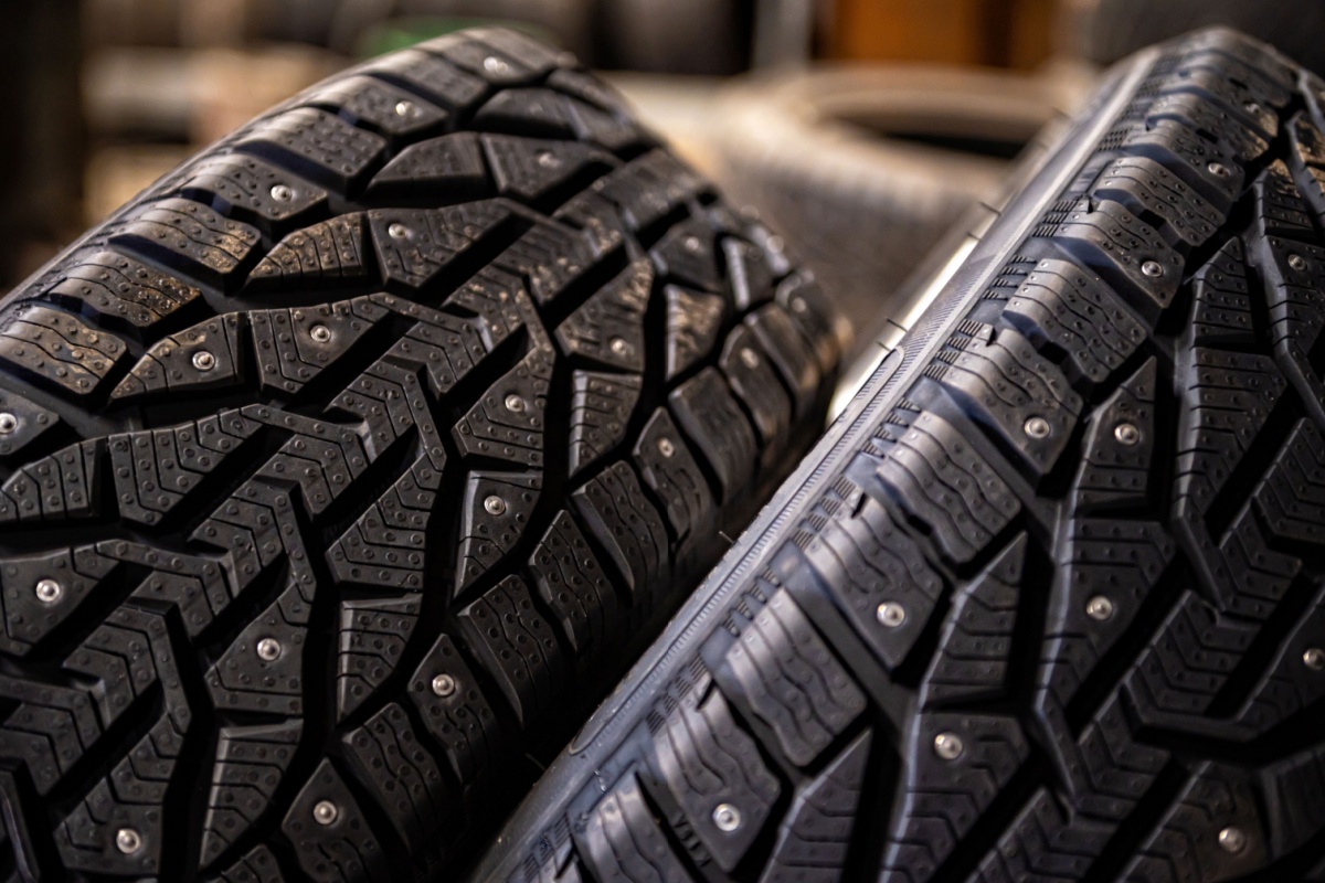 Close-up of studded tires, showcasing the metal studs designed for enhanced traction on icy surfaces.