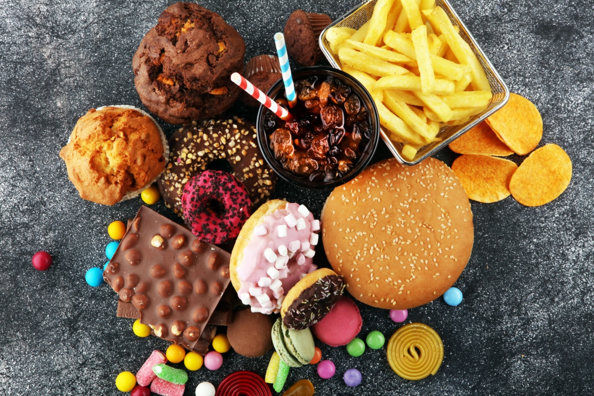 A selection of food items showcasing donuts, hamburgers, and candy, presented together in a vibrant display.