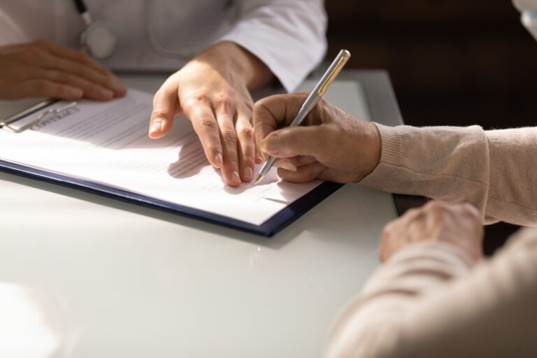 A doctor and patient review a document together, focusing on power of attorney and its implications for care decisions.