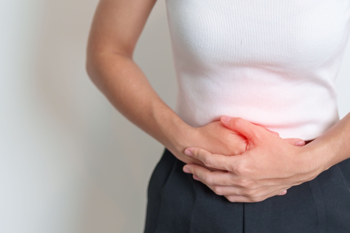 A woman experiences abdominal pain, holding her stomach, amid rising concerns about ovarian cancer from talc powder in Ohio.