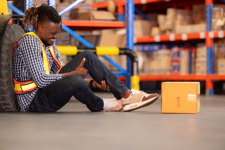 An injured warehouse worker sitting on the floor in front of a warehouse in Ohio.