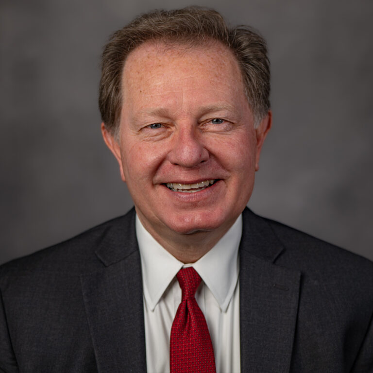 Attorney Mark Ropchock in a suit and tie, representing Slater & Zurz, stands confidently for a professional portrait.