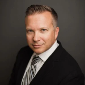 Jason St. George, an attorney at Slater and Zurz, poses in a suit and tie for a professional photo.