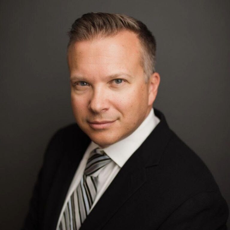 Jason St. George, an attorney at Slater and Zurz, poses in a suit and tie for a professional photo.