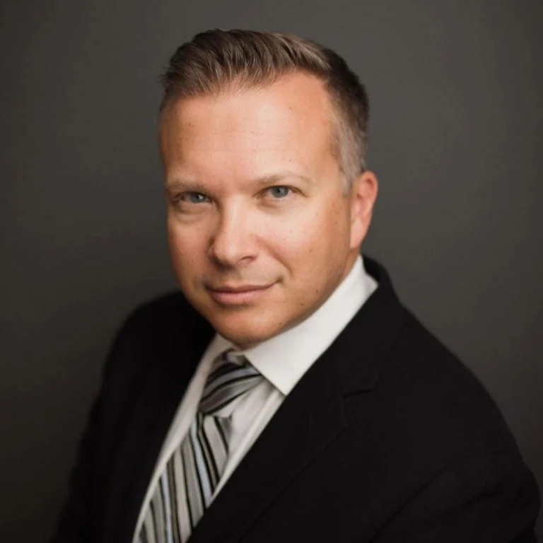 Jason St. George, an attorney at Slater and Zurz, poses in a suit and tie for a professional photo.