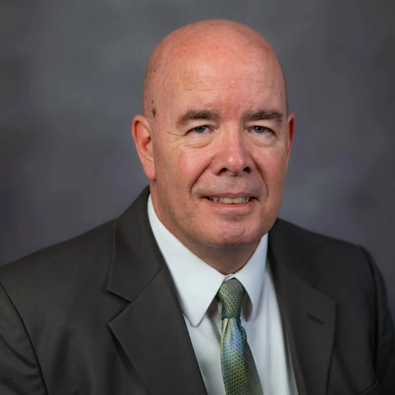 Jeff Hawkins sits in a suit and tie, representing Slater & Zurz, stands confidently for a professional portrait.