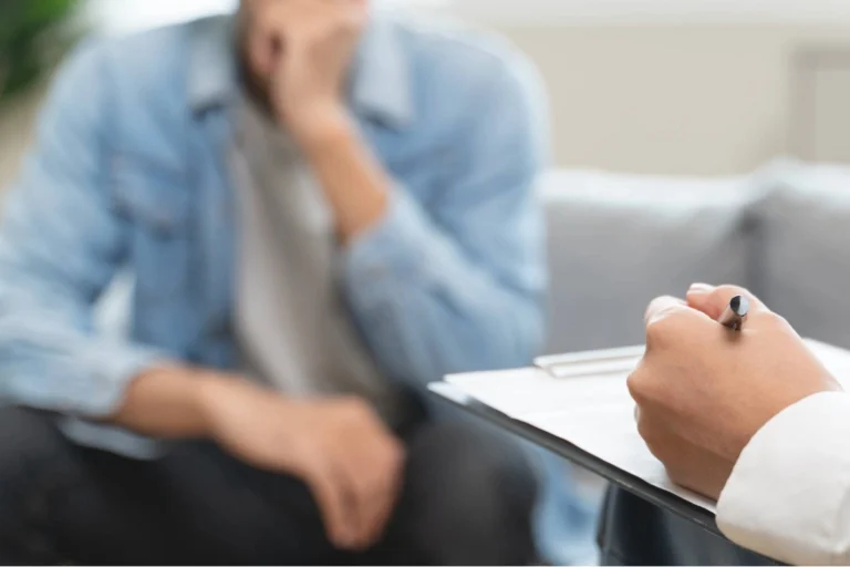 Therapist taking notes during a counseling session with a client discussing trauma after a personal injury