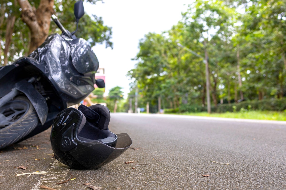 Overturned black motorcycle and helmet on Ohio road after crash – illustrating impact of Ohio motorcycle helmet law on injury claims